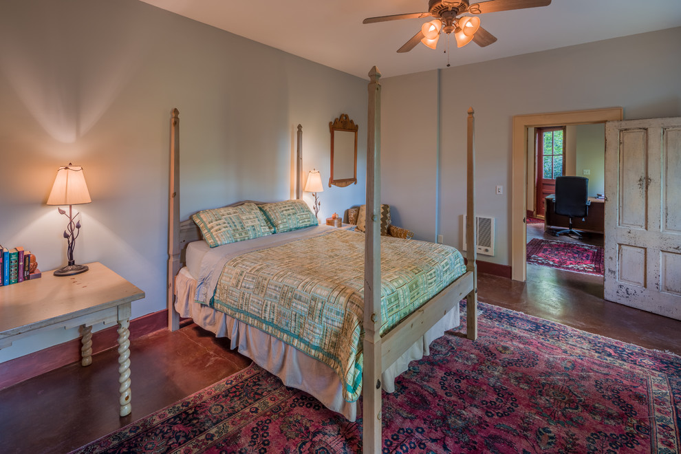 Foto de habitación de invitados rústica grande con paredes beige y suelo de cemento