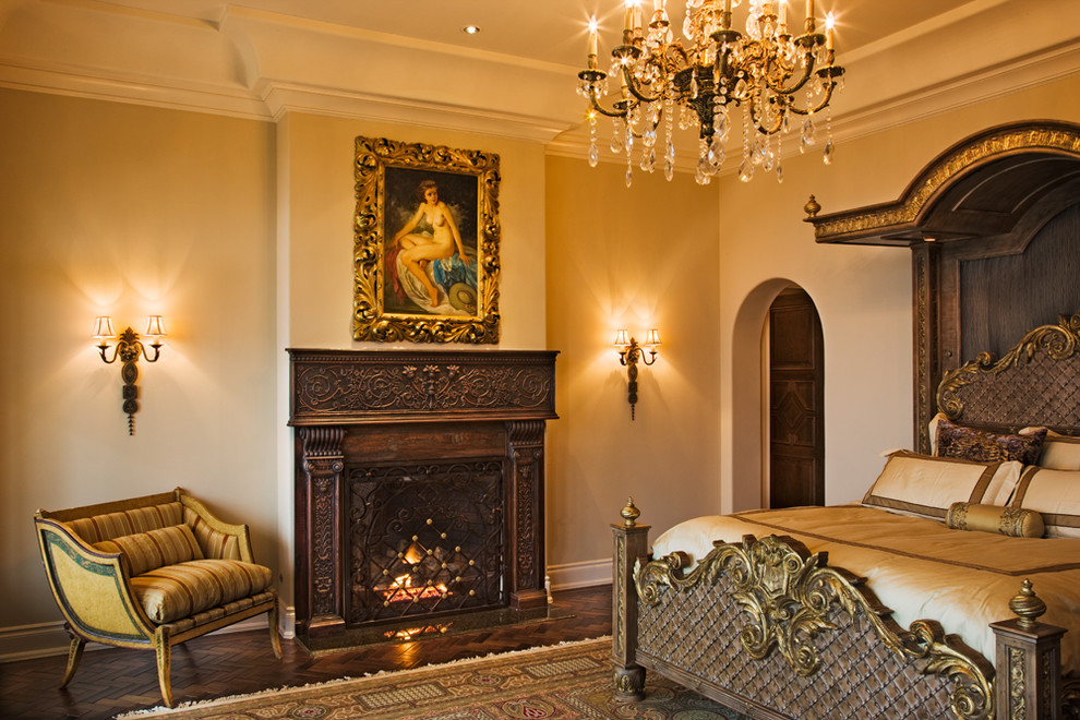 Foto di una camera matrimoniale mediterranea di medie dimensioni con pareti beige, parquet scuro e camino classico