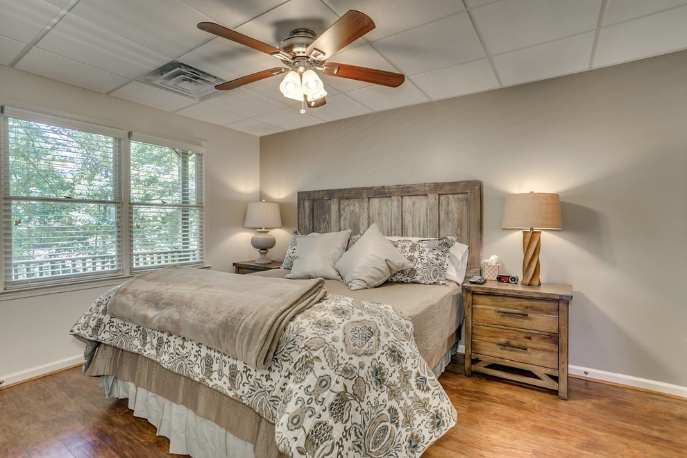 Ejemplo de habitación de invitados romántica de tamaño medio sin chimenea con paredes beige y suelo de madera en tonos medios