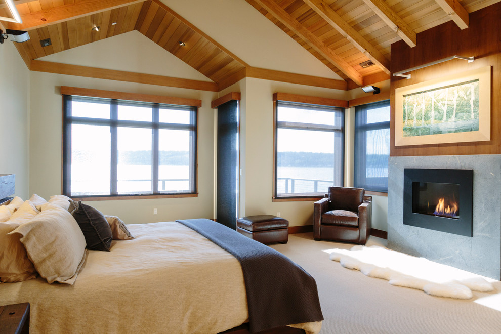 シアトルにある広いラスティックスタイルのおしゃれな主寝室 (ベージュの壁、カーペット敷き、標準型暖炉、金属の暖炉まわり)