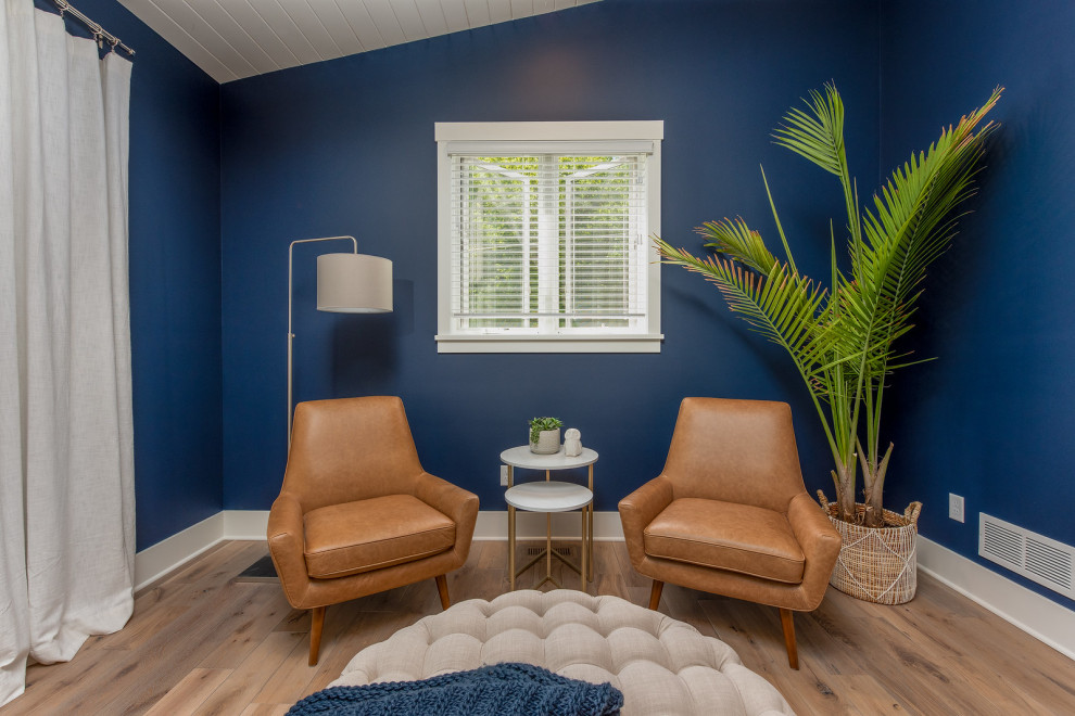 Aménagement d'une grande chambre parentale bord de mer avec un mur bleu, un sol en bois brun et un plafond en lambris de bois.