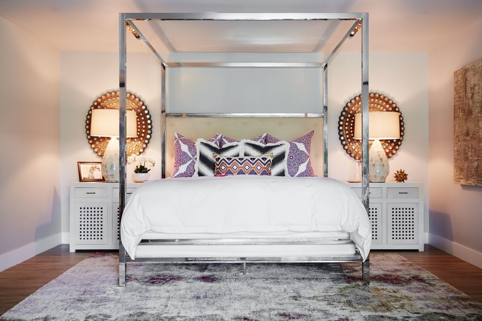 Modelo de dormitorio principal ecléctico de tamaño medio con paredes blancas y suelo de madera en tonos medios