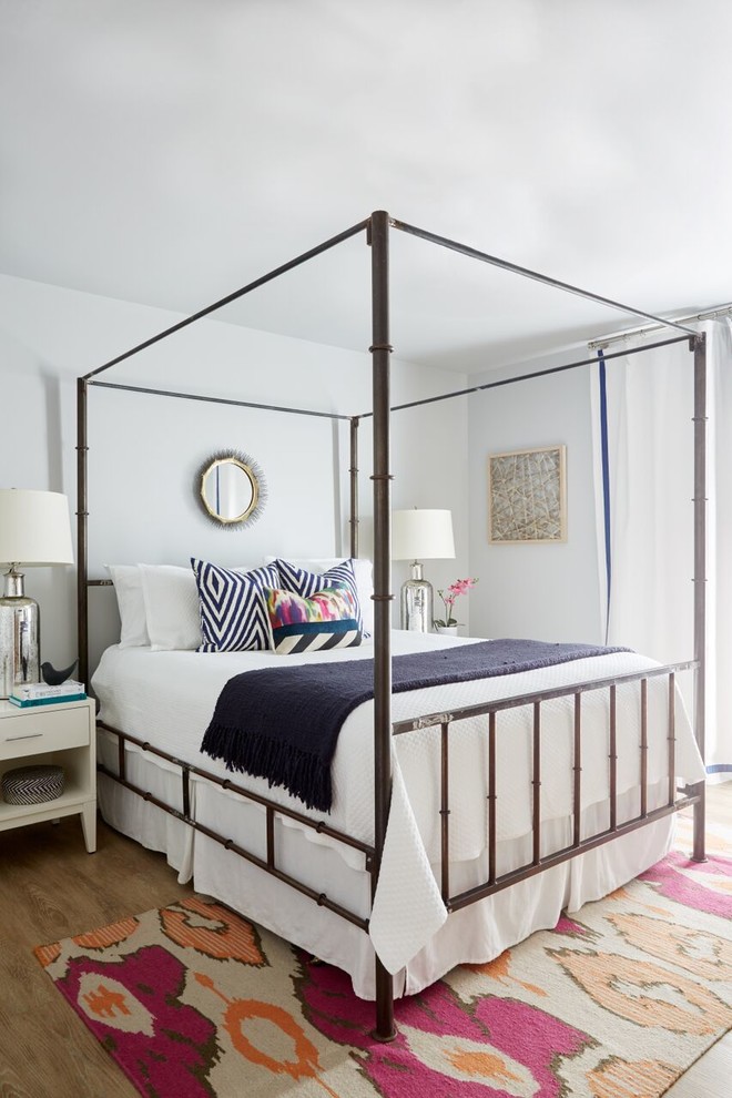 Imagen de habitación de invitados ecléctica de tamaño medio con paredes blancas y suelo de madera en tonos medios
