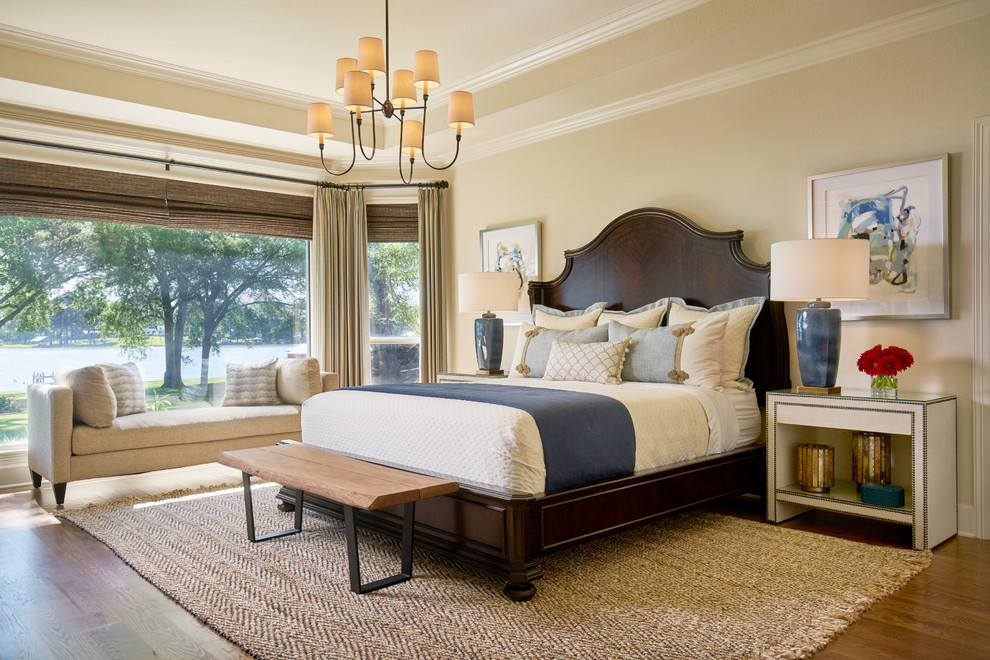Foto de dormitorio principal clásico grande sin chimenea con paredes beige, suelo de madera en tonos medios y suelo marrón