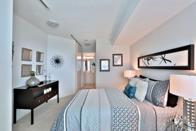 Foto de dormitorio principal actual de tamaño medio sin chimenea con paredes beige, moqueta y suelo beige