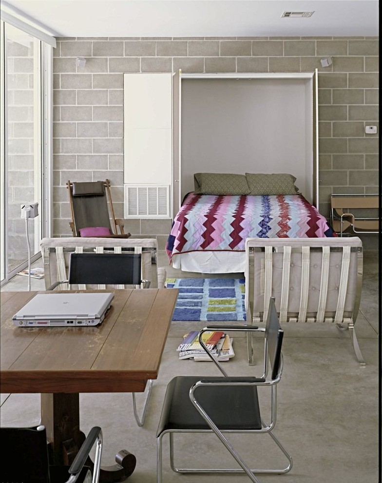 Foto di una piccola camera da letto moderna con pareti grigie e pavimento in cemento