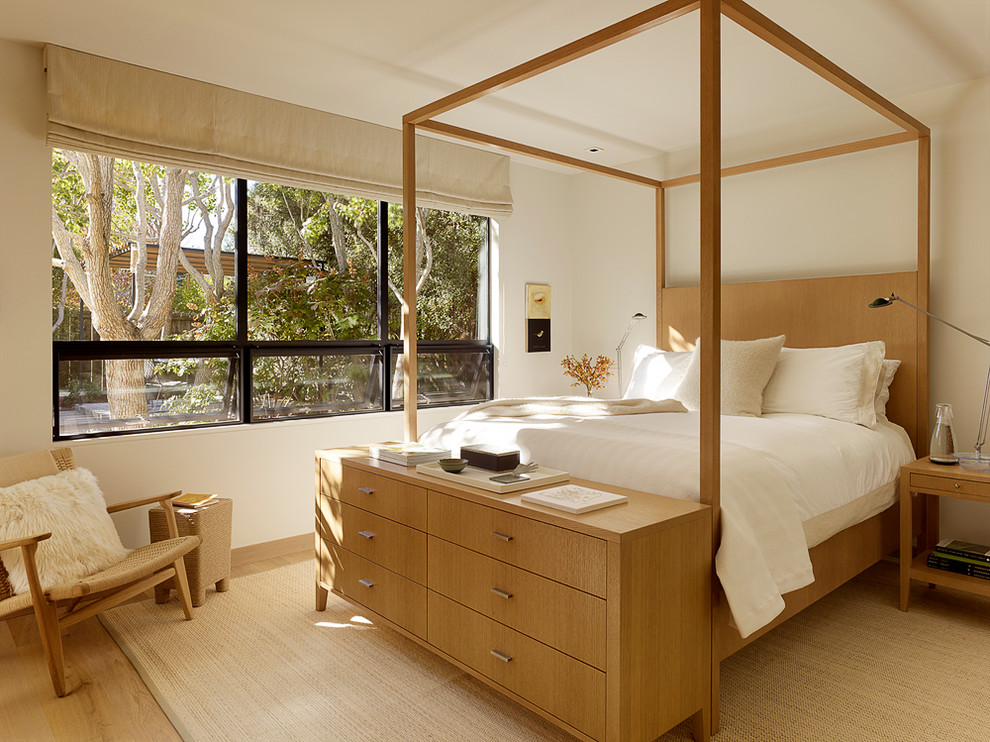 Ejemplo de dormitorio principal moderno de tamaño medio sin chimenea con paredes blancas y suelo de madera clara