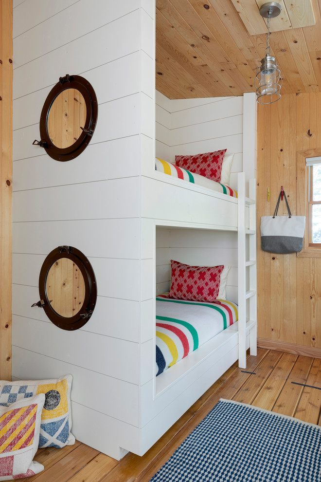 Esempio di una camera degli ospiti costiera con pareti beige, pavimento in legno massello medio e soffitto in perlinato