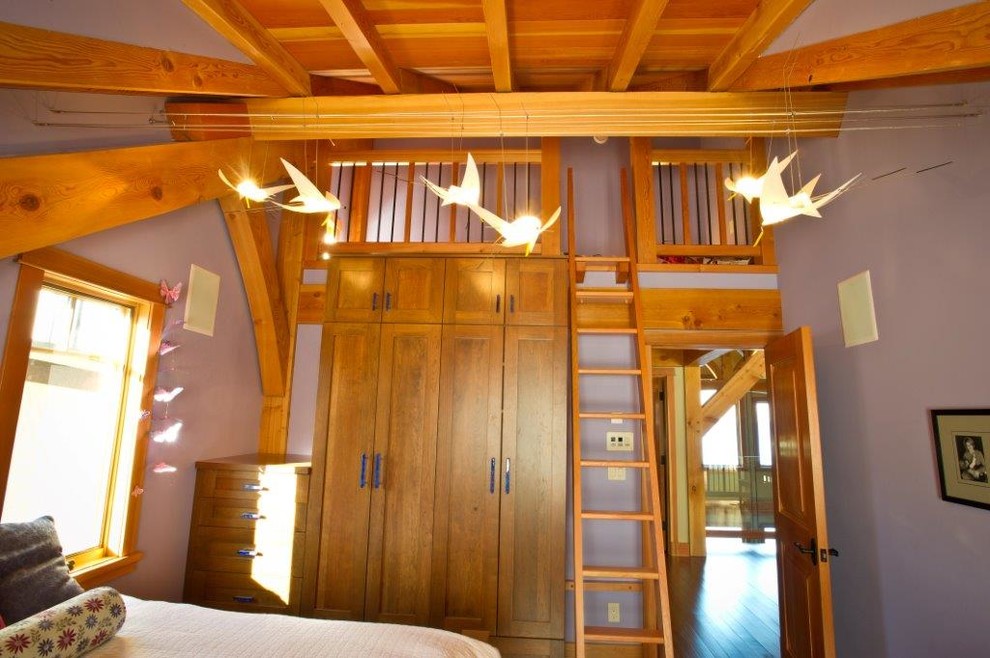 Cette image montre une chambre mansardée ou avec mezzanine traditionnelle de taille moyenne avec un mur violet et un sol en bois brun.