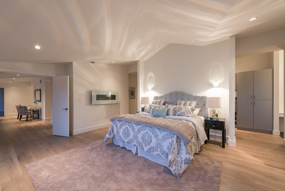 Klassisches Hauptschlafzimmer mit weißer Wandfarbe, hellem Holzboden und Gaskamin in Vancouver