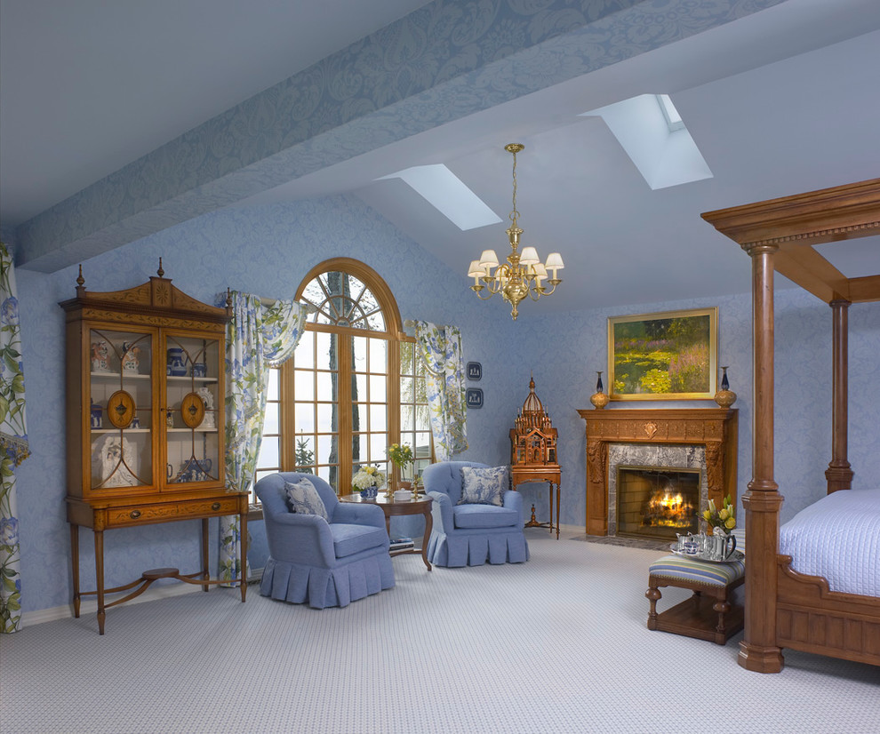 This is an example of a traditional master bedroom in Cleveland with blue walls, a standard fireplace and a wood fireplace surround.