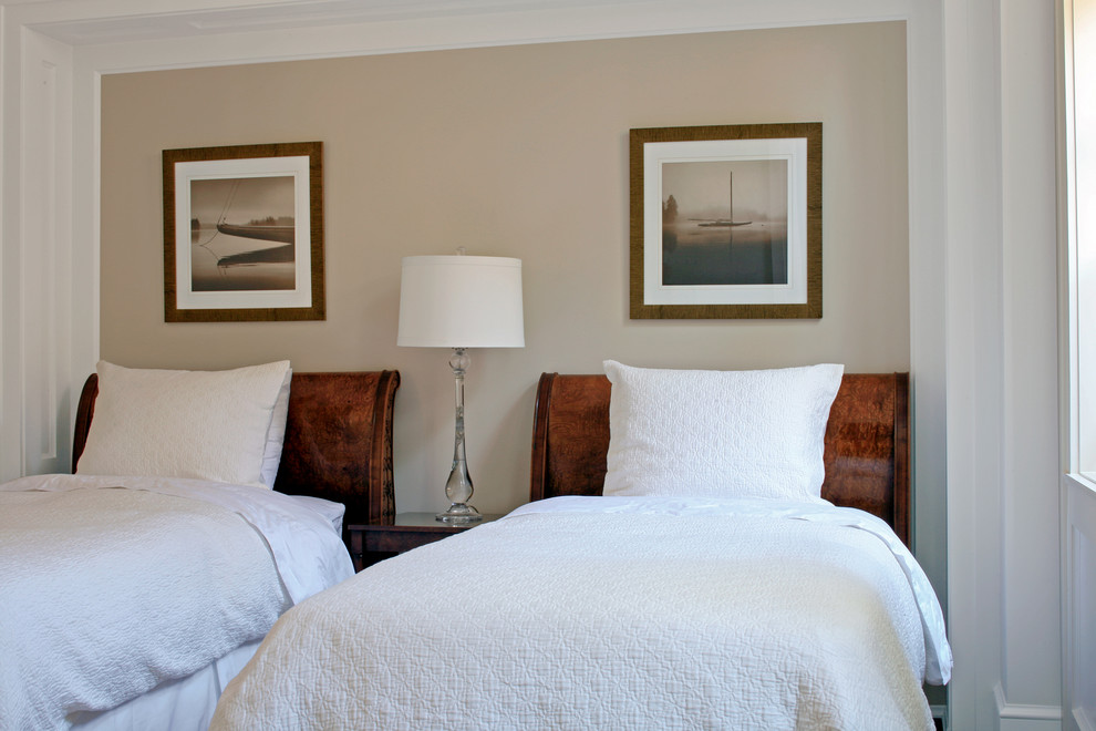 Cette image montre une grande chambre d'amis traditionnelle avec un mur beige et parquet foncé.