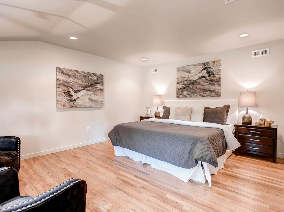Modelo de dormitorio principal actual de tamaño medio con paredes blancas, suelo de madera clara y suelo beige