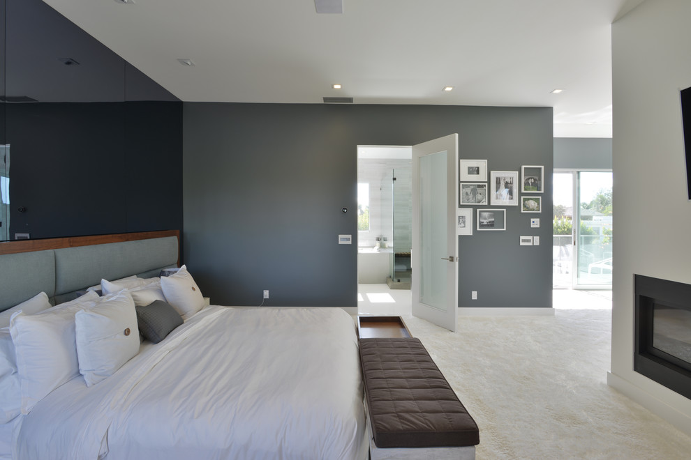 Großes Modernes Hauptschlafzimmer mit grauer Wandfarbe, Teppichboden, Kamin und Kaminumrandung aus Metall in Los Angeles