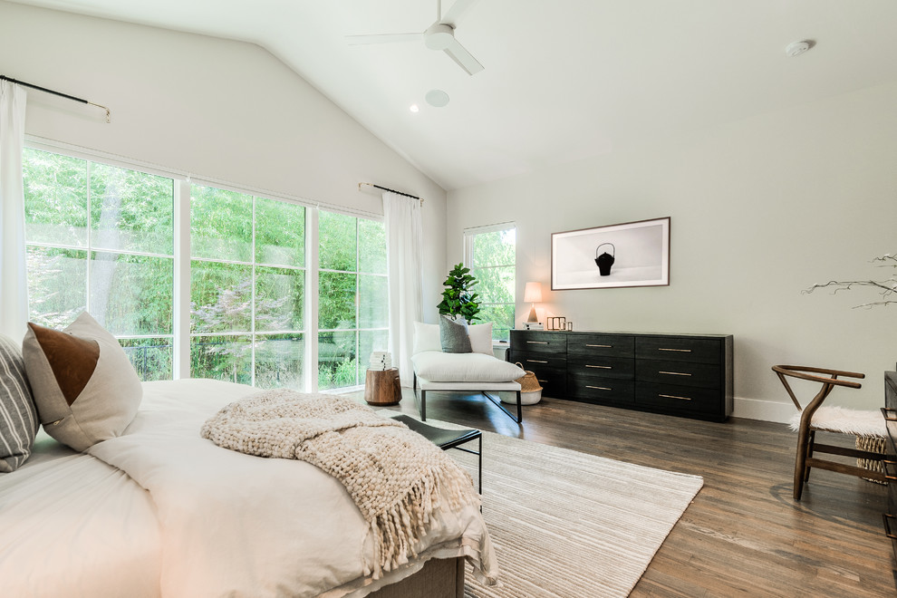 Imagen de dormitorio principal contemporáneo grande sin chimenea con paredes blancas y suelo de madera en tonos medios