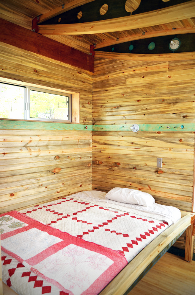 Inspiration för ett litet rustikt sovrum, med mellanmörkt trägolv