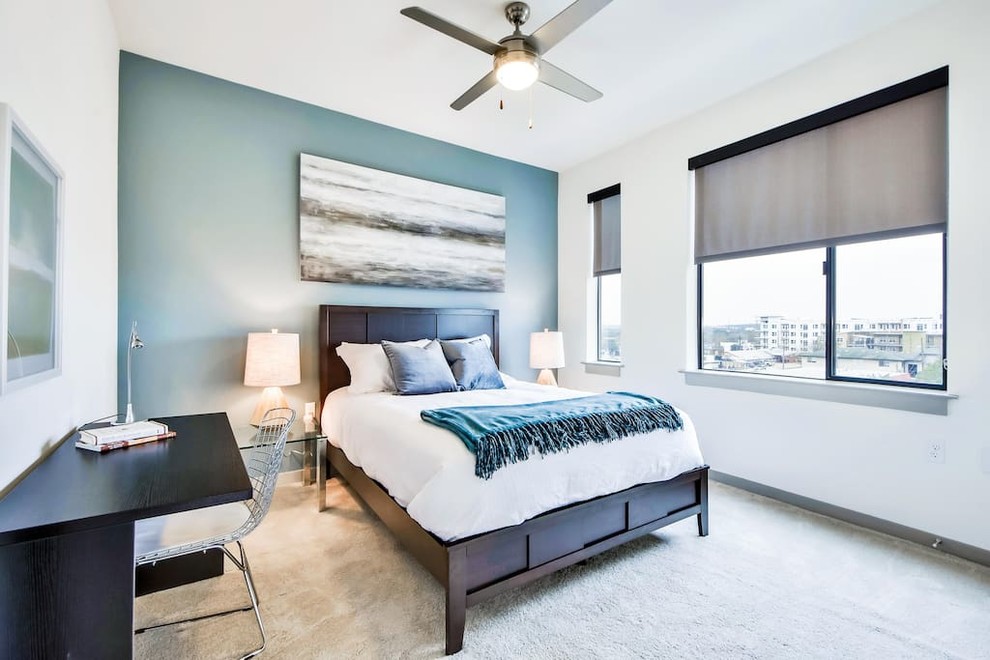 Immagine di una camera da letto contemporanea con pareti blu, moquette e pavimento beige