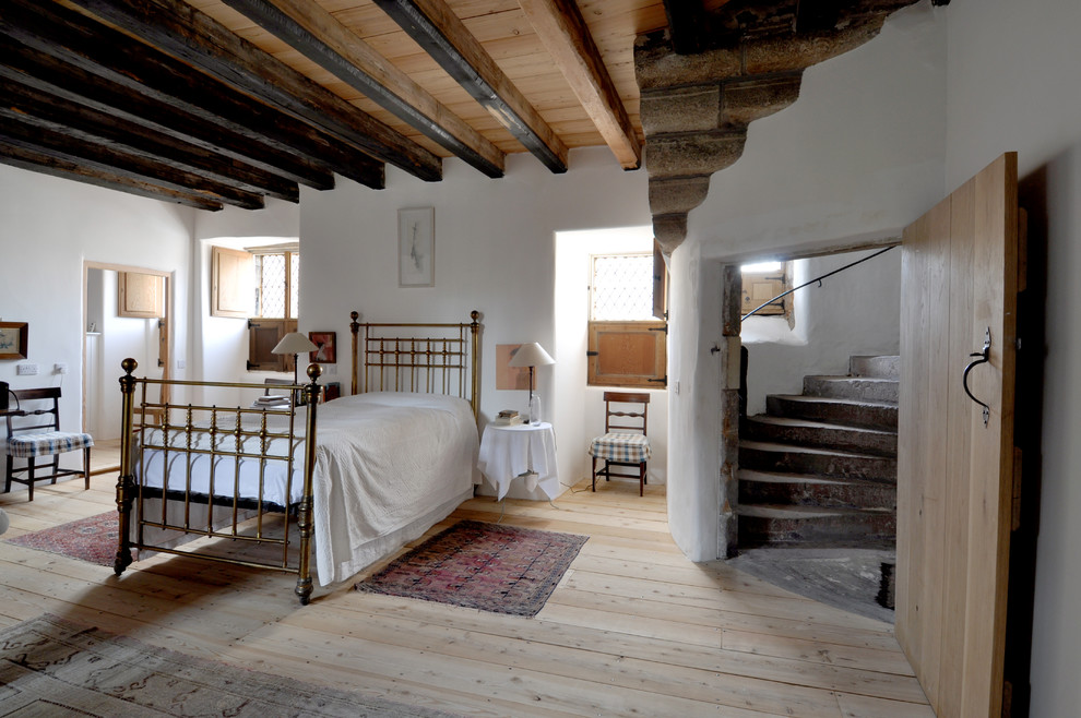 Exemple d'une grande chambre d'amis montagne avec un mur blanc et parquet clair.