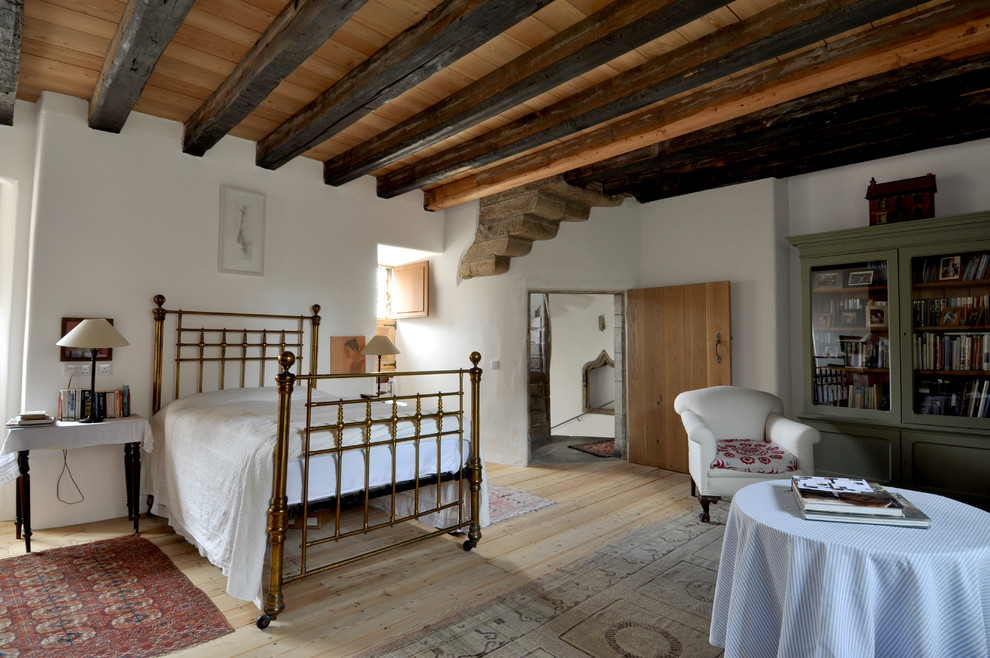 Modelo de habitación de invitados tradicional grande con paredes blancas y suelo de madera clara