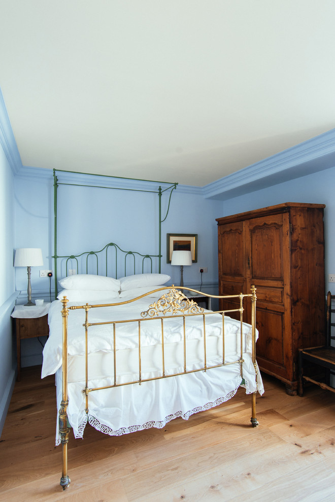 Idee per una camera degli ospiti tradizionale di medie dimensioni con pareti blu, pavimento in legno massello medio e nessun camino