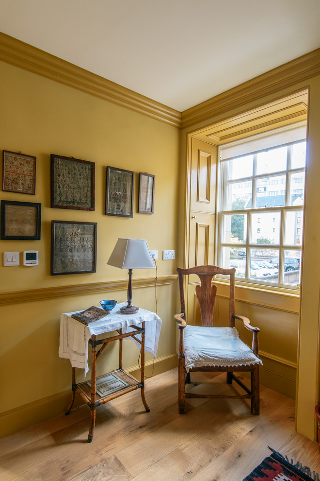 Mittelgroßes Klassisches Gästezimmer ohne Kamin mit gelber Wandfarbe und braunem Holzboden in Edinburgh