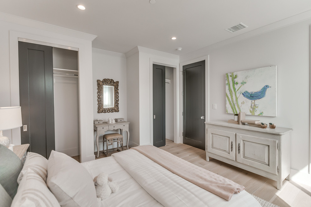 Ejemplo de habitación de invitados contemporánea grande sin chimenea con paredes blancas, suelo de madera clara y suelo marrón
