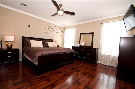 Mid-sized transitional master dark wood floor and brown floor bedroom photo in Orlando with beige walls