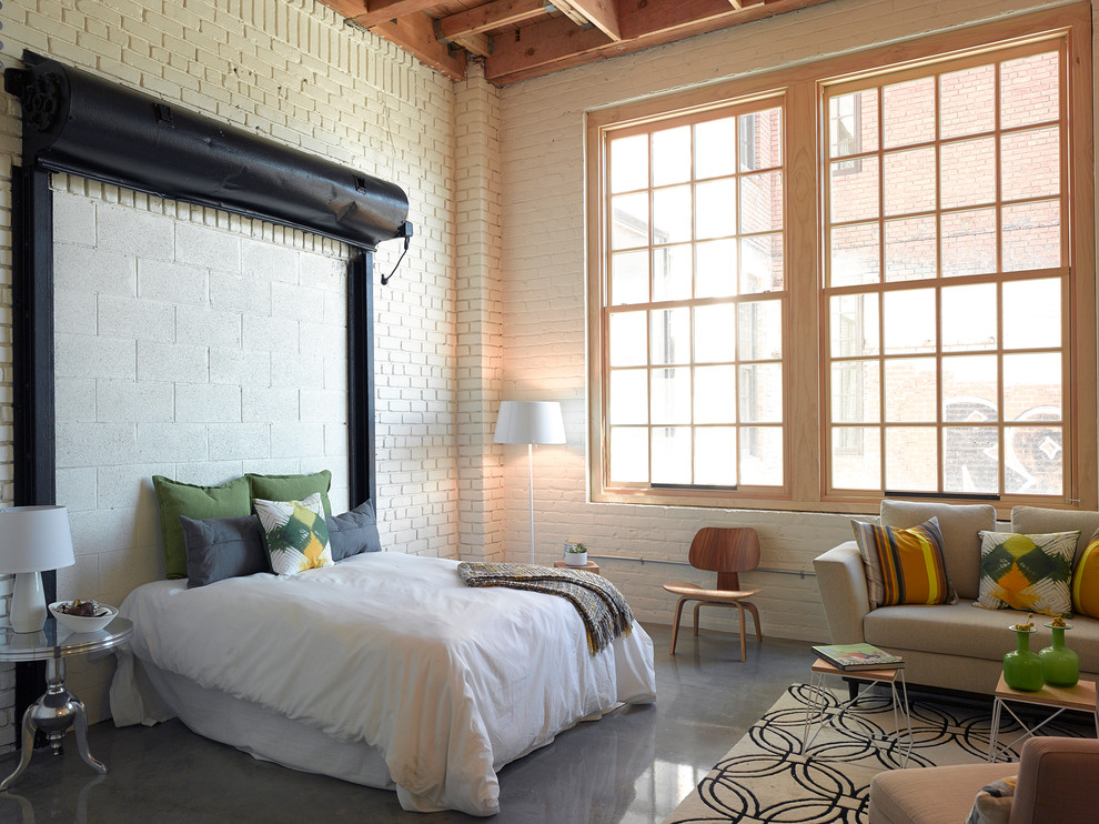 Bedroom - large industrial loft-style concrete floor bedroom idea in San Francisco with white walls