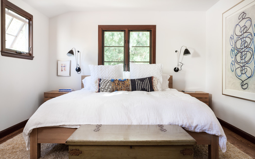 Foto på ett vintage sovrum, med vita väggar, mellanmörkt trägolv och brunt golv