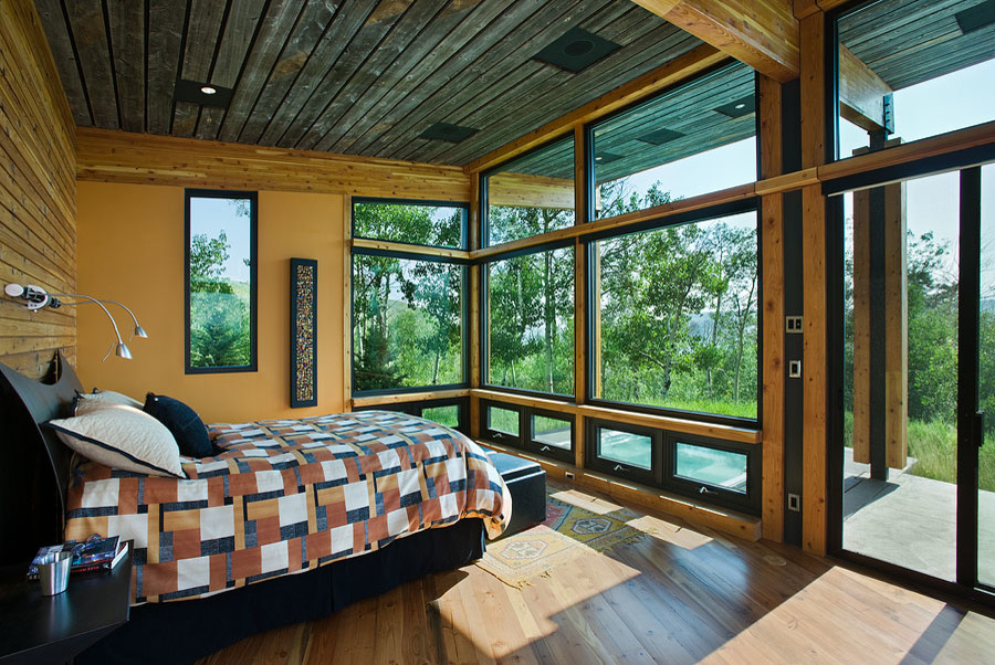Foto di una camera matrimoniale di medie dimensioni con pareti gialle e pavimento in legno massello medio