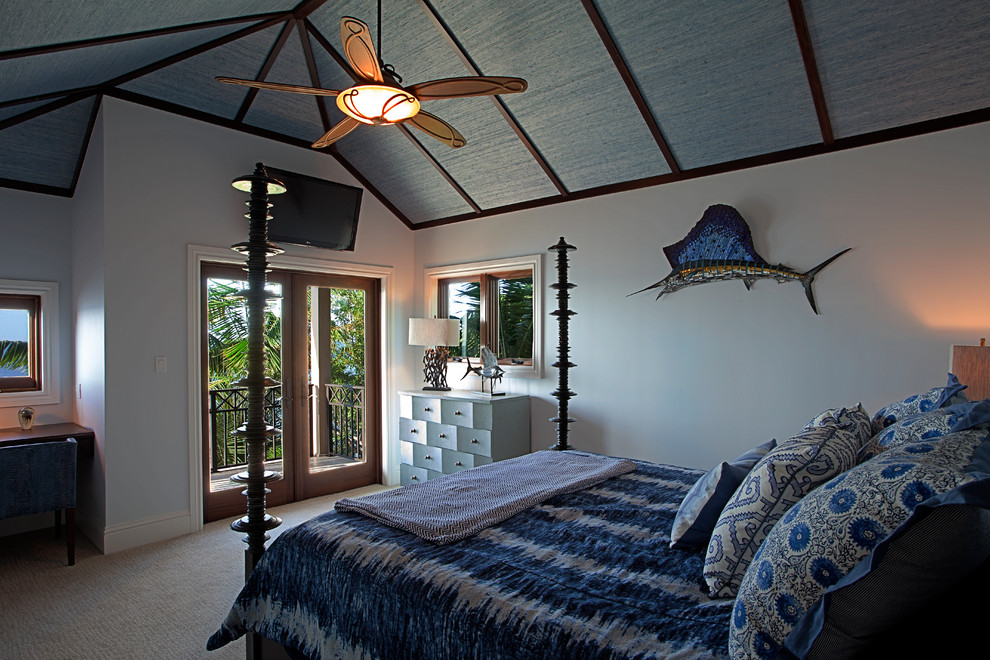 Immagine di una grande camera degli ospiti tropicale con pareti bianche, moquette, nessun camino e pavimento beige