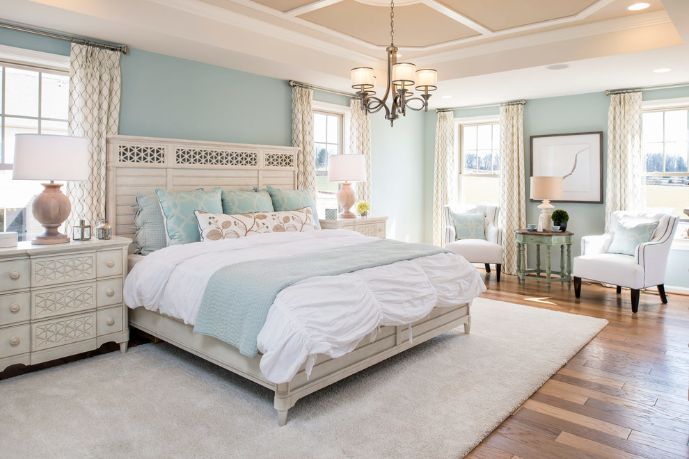 Ejemplo de dormitorio de estilo de casa de campo con paredes azules y suelo de madera en tonos medios