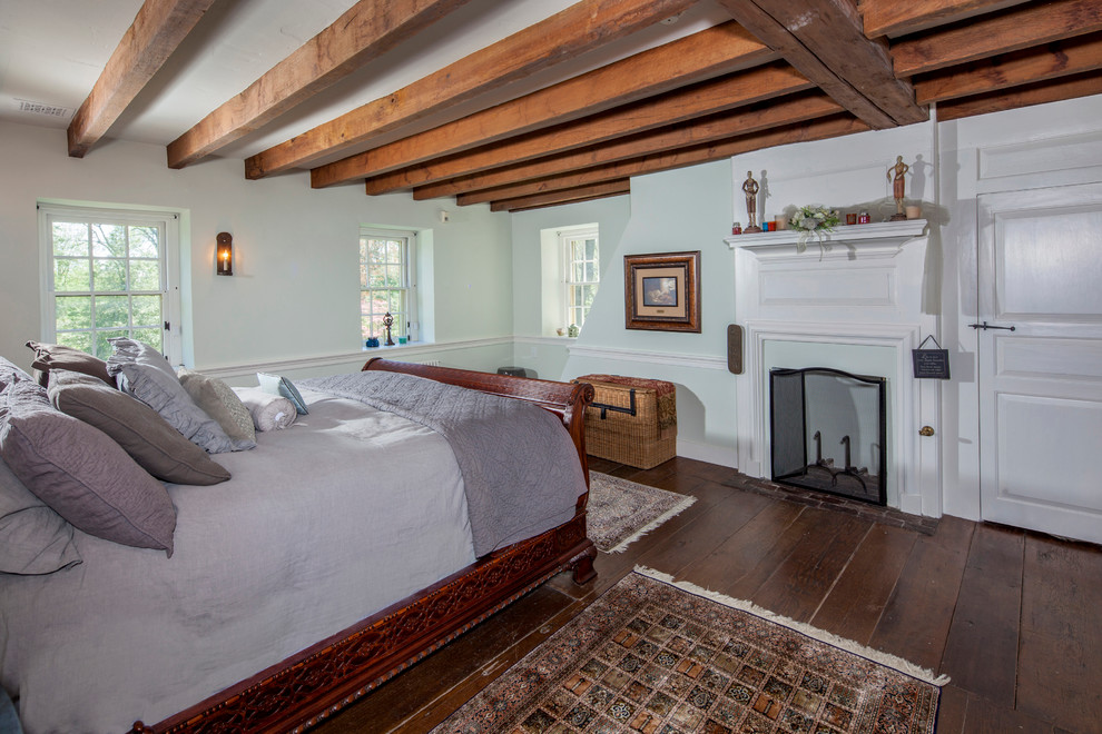 Ejemplo de dormitorio tradicional con suelo de madera en tonos medios y todas las chimeneas