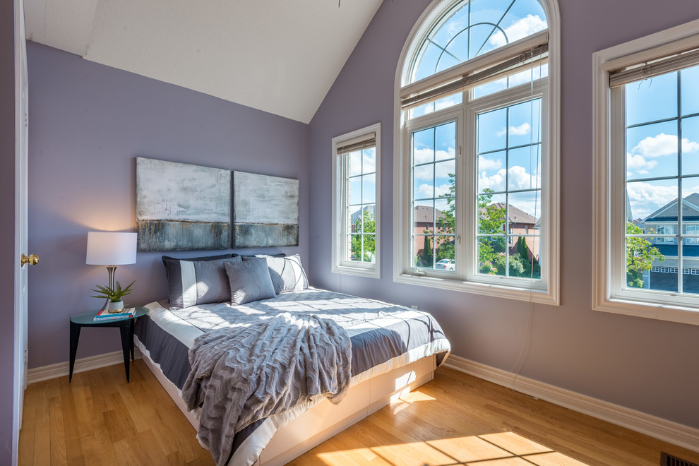 Ejemplo de habitación de invitados contemporánea pequeña con paredes púrpuras, suelo de madera clara y suelo amarillo