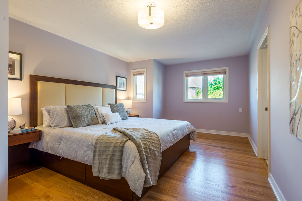 Imagen de dormitorio principal contemporáneo de tamaño medio con paredes púrpuras, suelo de madera clara y suelo amarillo