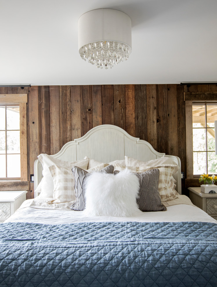 Inspiration for a country bedroom in Other with brown walls, dark hardwood flooring, a standard fireplace, a brick fireplace surround and brown floors.