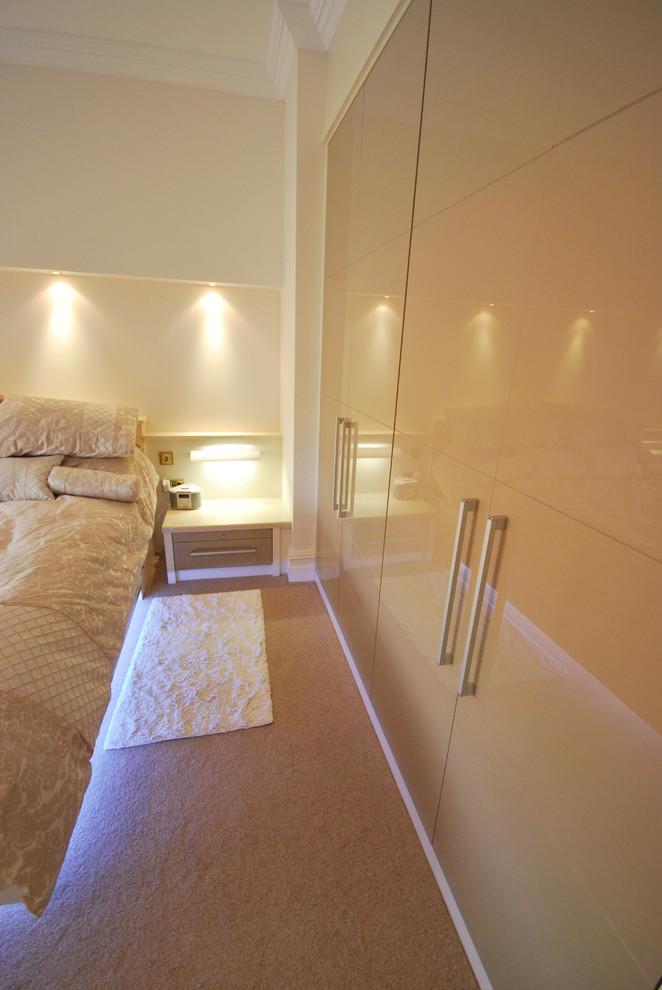 Inspiration for a large contemporary master bedroom in Manchester with beige walls and carpet.