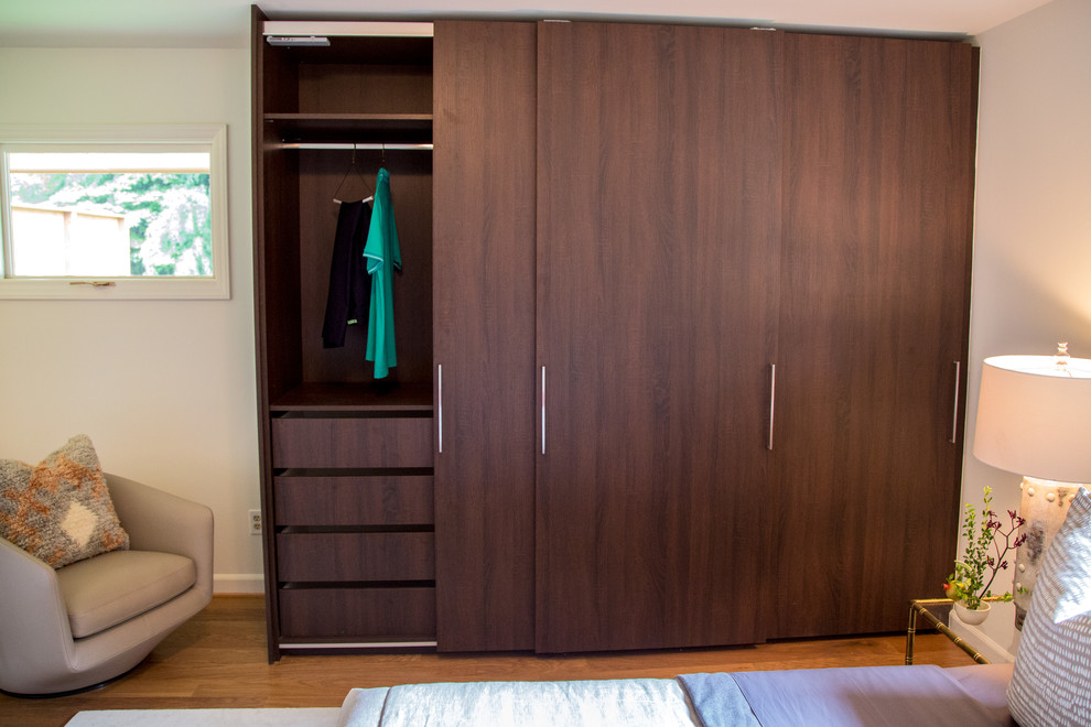 Modelo de dormitorio moderno grande con suelo laminado y suelo marrón