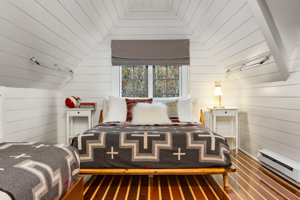 Modernes Schlafzimmer im Dachboden mit weißer Wandfarbe, braunem Holzboden und braunem Boden in New York