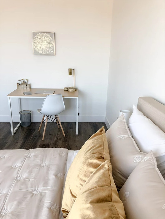 Réalisation d'une chambre parentale minimaliste de taille moyenne avec un mur blanc, parquet foncé et un sol marron.