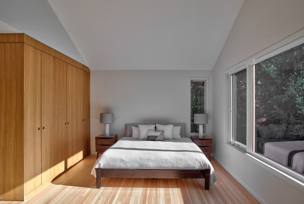 Inspiration för mellanstora minimalistiska sovrum, med vita väggar och ljust trägolv