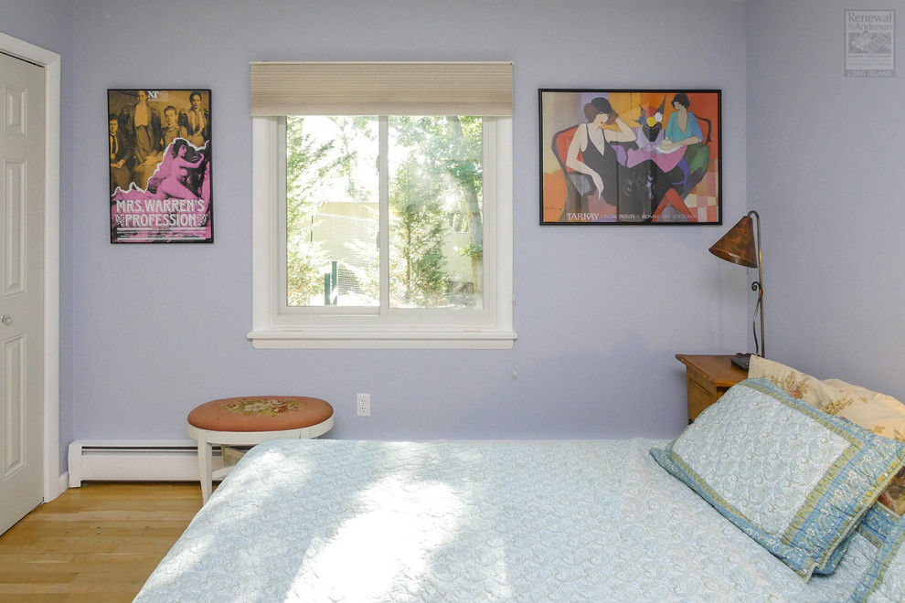 Foto de dormitorio de tamaño medio sin chimenea con paredes púrpuras y suelo de madera clara