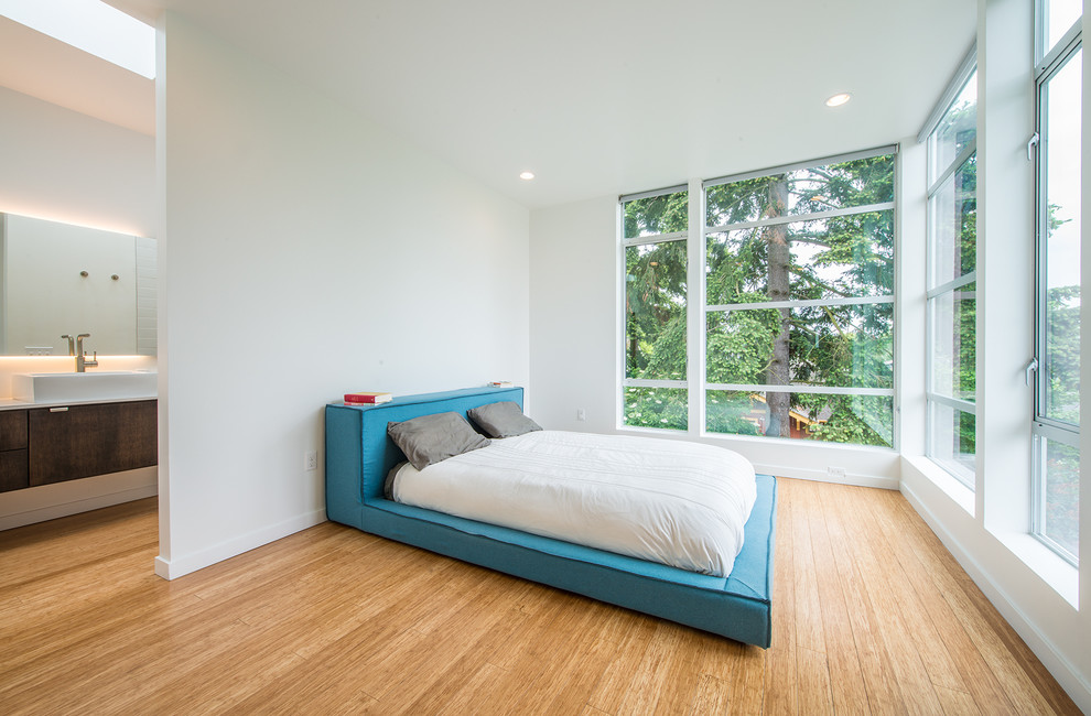 Mittelgroßes Modernes Hauptschlafzimmer ohne Kamin mit weißer Wandfarbe und braunem Holzboden in Seattle