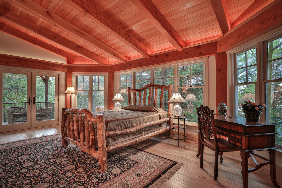 This is an example of a classic master bedroom in Burlington with grey walls and light hardwood flooring.