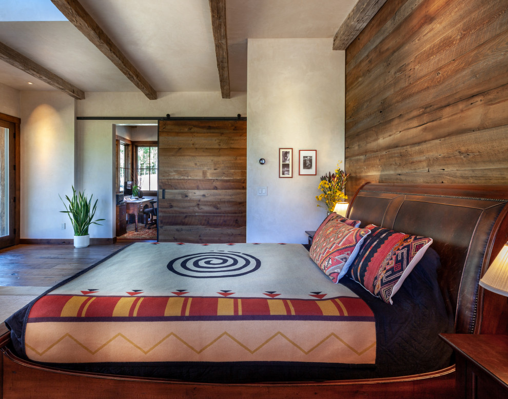 Inspiration for a mid-sized rustic master dark wood floor and brown floor bedroom remodel in Denver with beige walls and no fireplace