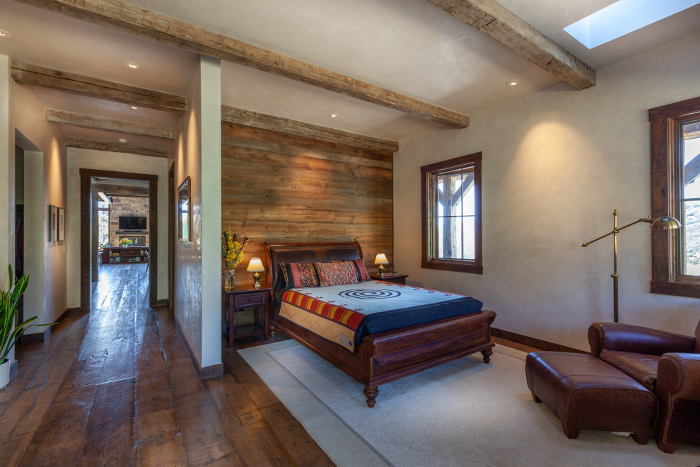 Diseño de dormitorio principal rural de tamaño medio sin chimenea con paredes beige, suelo de madera oscura y suelo marrón