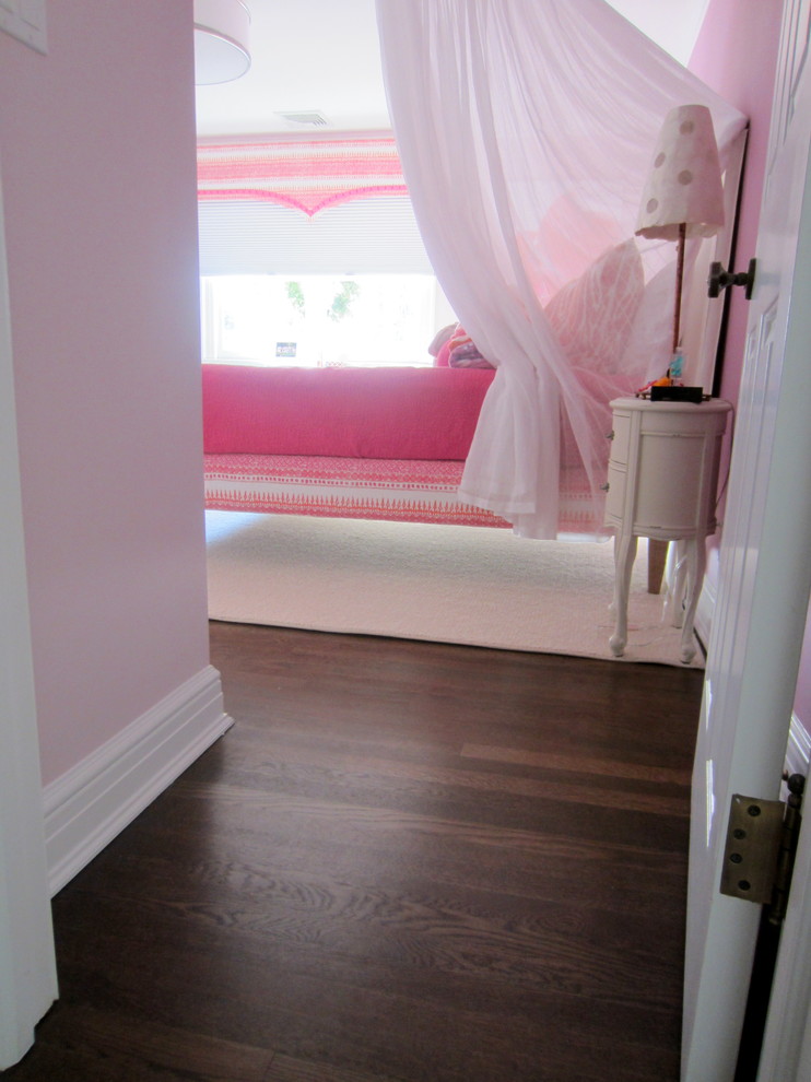 Imagen de dormitorio principal tradicional renovado de tamaño medio sin chimenea con paredes rosas y suelo de madera oscura