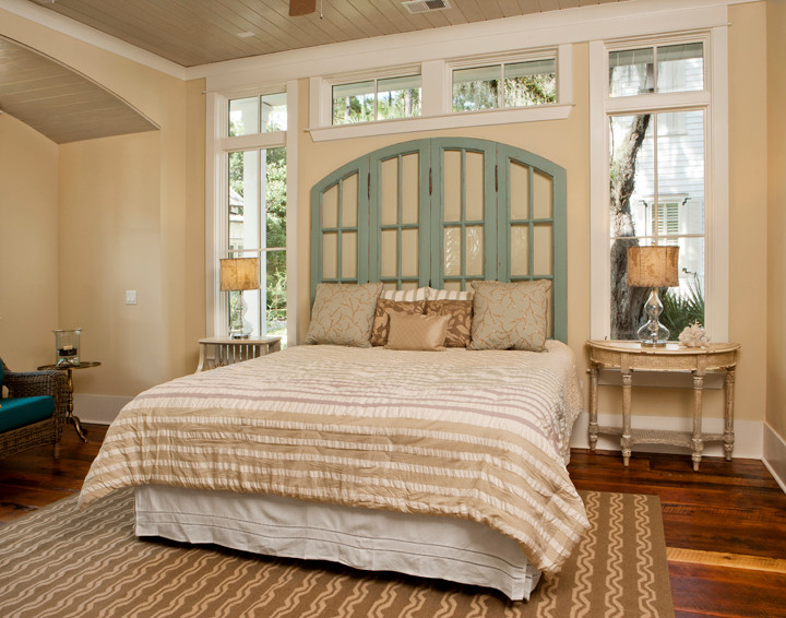 Modelo de dormitorio principal marinero grande con paredes beige y suelo de madera en tonos medios