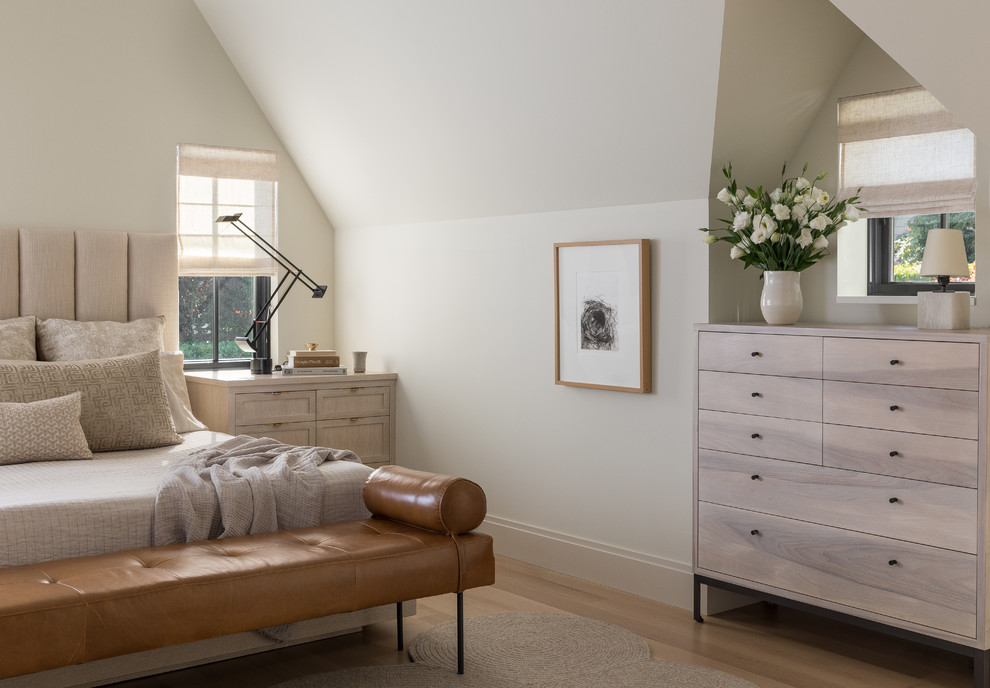 Diseño de dormitorio principal tradicional renovado grande con paredes beige, suelo de madera clara, chimenea de esquina, marco de chimenea de madera y suelo beige
