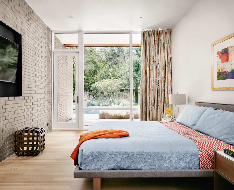 Klassisches Schlafzimmer ohne Kamin mit weißer Wandfarbe und hellem Holzboden in Austin